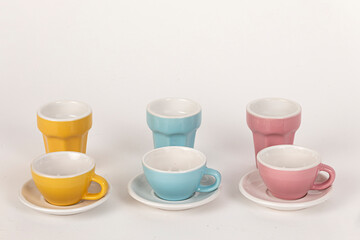Tazas y vasos de porcelana en rosas, azules y amarillos.