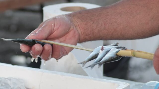 Espeteros skewering sardines in espetos, typical spanish food