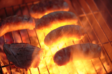 Barbecue of meat and sausage on the fire on the grill.