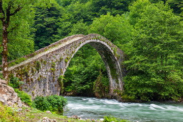 Fototapeta na wymiar Stone bridge on Firtina Stream in Camlihemsin, Rize, Turkey. Beautiful nature landscape.