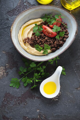 Bowl of hummus with ground beef meat on a brown stone background, elevated view, vertical shot with space