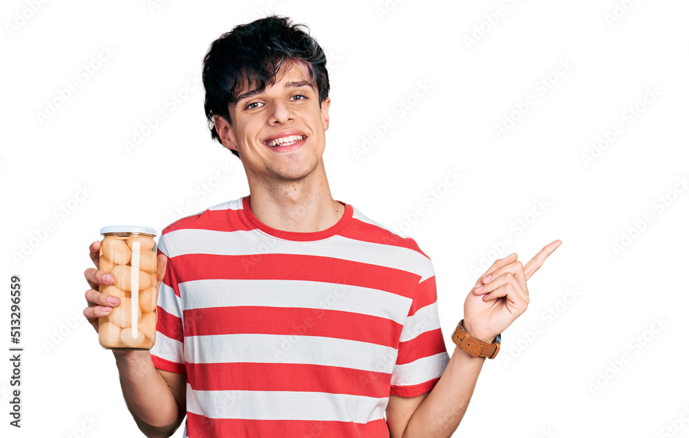 Sticker Handsome hipster young man holding bottle with boiled potatoes smiling happy pointing with hand and finger to the side