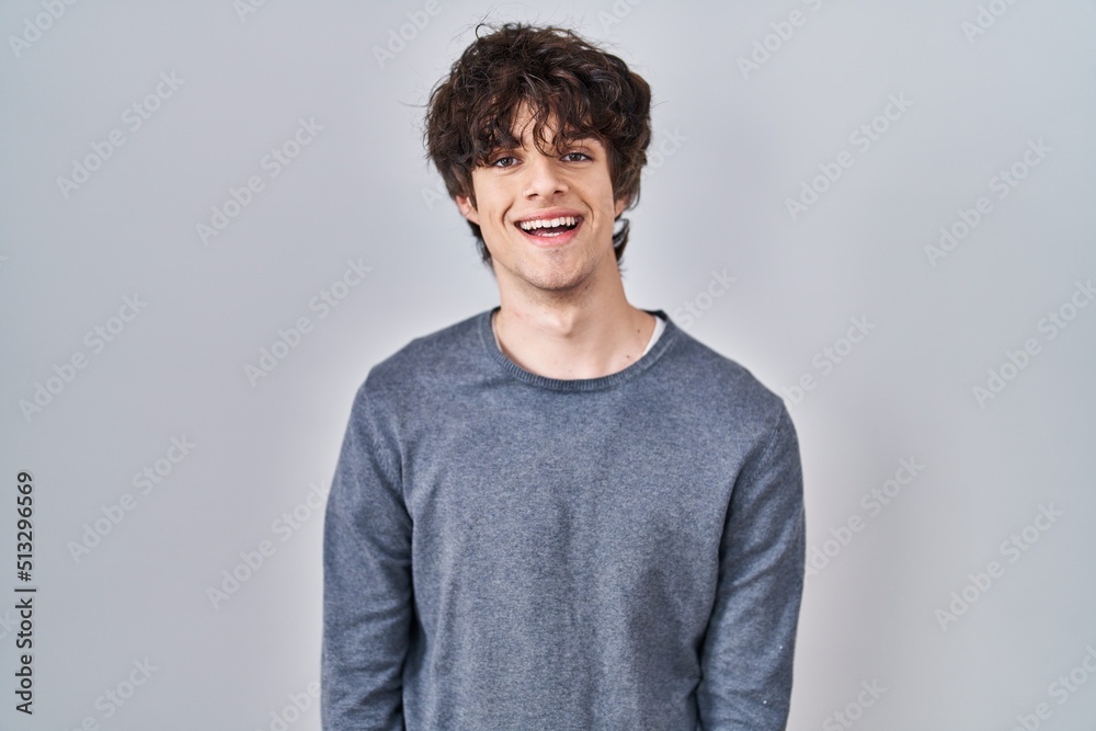 Canvas Prints Young man standing over isolated background with a happy and cool smile on face. lucky person.