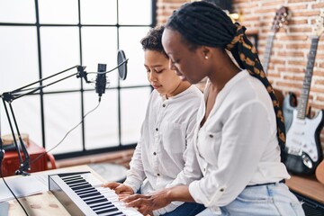 African american mother and son student learning play piano at music studio