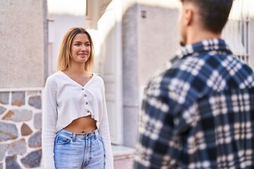 Young man and woman couple smiling confident standing together at street