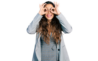 Young hispanic girl wearing business clothes and glasses doing ok gesture like binoculars sticking tongue out, eyes looking through fingers. crazy expression.