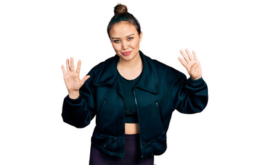 Young hispanic girl wearing sportswear showing and pointing up with fingers number nine while...