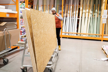 Obraz na płótnie Canvas customer inspecting OSB panels in a repair supply store