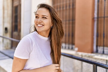 Attractive and beautiful hispanic woman smiling happy on a sunny day outdoors. Pretty brunette girl...