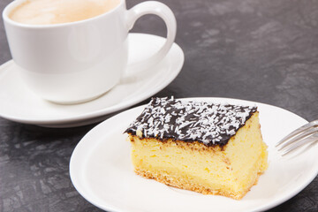Cup of white coffee and fresh baked cheesecake. Delicious dessert