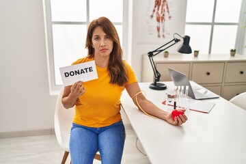 Hispanic woman supporting blood donation depressed and worry for distress, crying angry and afraid....