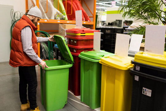 a man chooses a bin for sorting garbage and household waste