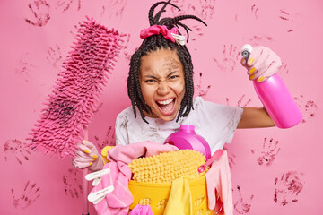 Spring cleaning and housekeeping concept. Young housemaid exclaims loudly holds mop and bottle of...
