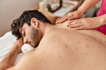 Fototapeta na wymiar Man relaxed reciving back massage at beauty center.
