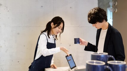 カフェでクレジットカード決済をする男性