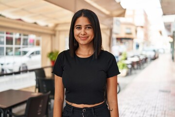 Young latin woman smiling confident standing at street