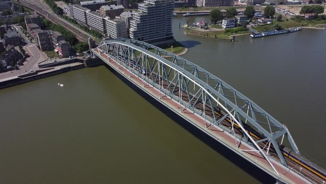 Railroad Bridge with yellow train over river Waal in Nijmegen, The Netherlands, Aerial
