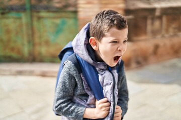 Blond child student screaming at street