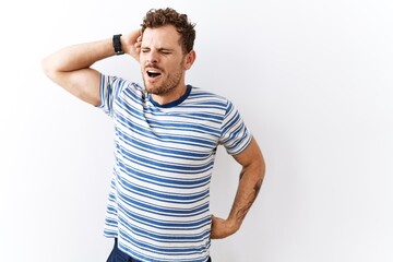 Handsome young man standing over isolated background stretching back, tired and relaxed, sleepy and yawning for early morning