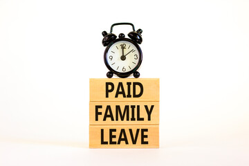 Paid family leave symbol. Concept words Paid family leave on wooden blocks. Black alarm clock. Beautiful white table white background. Business medical and paid family leave concept. Copy space.