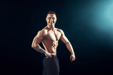 Fototapeta premium Power, strength, excellent body, bodybuilding, sports concept. Young handsome muscular fit man demonstrating perfect body