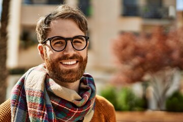 Young caucasian man with beard wearing glasses outdoors on a sunny day