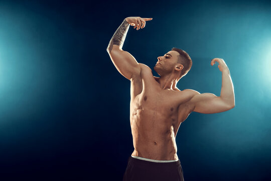 Power, strength, excellent body, bodybuilding, sports concept. Young handsome muscular fit man demonstrating perfect body