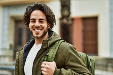 Handsome hispanic man smiling at the city