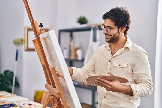 Young hispanic man artist smiling confident drawing at art studio
