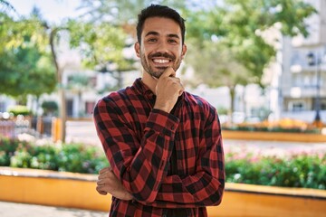 Young hispanic man smiling confident standing with arms crossed gesture at park