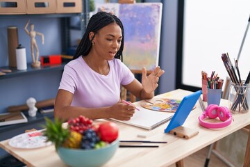 African american woman artist having online draw class at art studio