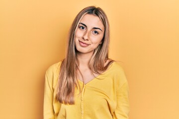 Obraz premium Beautiful hispanic woman wearing casual yellow sweater relaxed with serious expression on face. simple and natural looking at the camera.