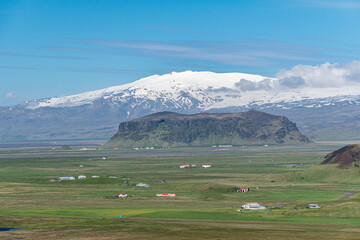 Panoramic view in southern Iceland with tuff mountain Petursey and Eyafjiallajokull volcano in the...
