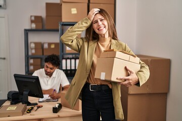 Young two people working at small business ecommerce stressed and frustrated with hand on head, surprised and angry face