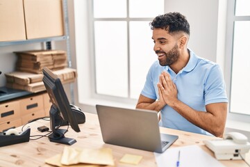 Young hispanic man ecommerce business worker using laptop at office