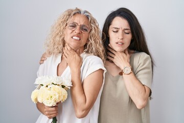 Mother and daughter holding bouquet of white flowers touching painful neck, sore throat for flu, clod and infection