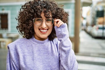 Young middle east woman smiling confident wearing glasses at street