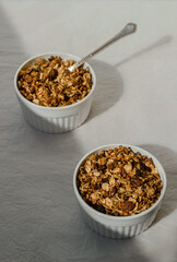 Two ceramic bowls with granola on white background 