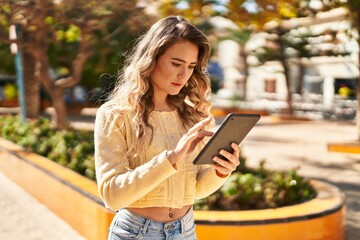 Obraz premium Young woman using touchpad at park