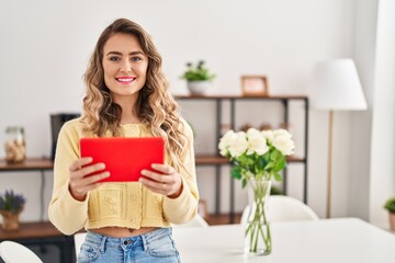 Young woman using touchpad standing at home