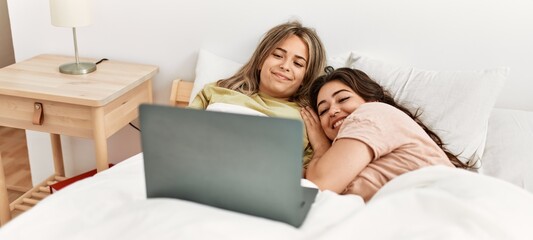 Young couple watching movie using laptop at bedroom
