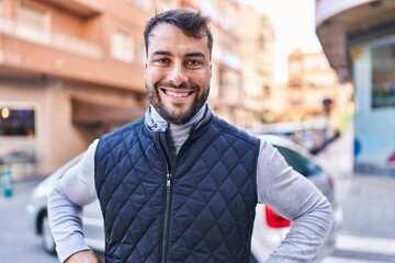 Obraz premium Young hispanic man smiling confident standing at street