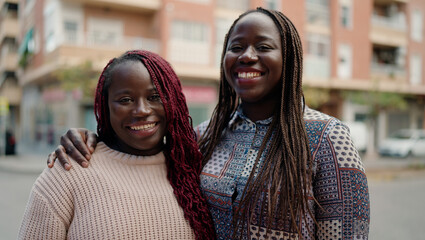 Naklejka premium Two african american friends smiling confident hugging each other standing at street