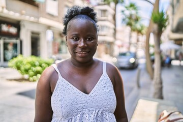 Young african american woman smiling happy standing at the city.