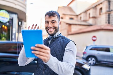 Young hispanic man smiling confident having video call at street