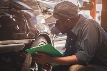 African maintenance male checking car, service via insurance system at automobile repair and check...
