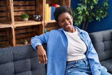 Fototapeta premium African american woman smiling confident sitting on sofa at home