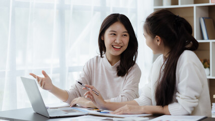 Two beautiful Asian women are meeting together in a company meeting room, meeting to discuss plans to develop the business to grow and follow the business plan. Business meeting idea.