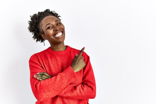 Young african american woman wearing casual clothes over isolated background with a big smile on face, pointing with hand and finger to the side looking at the camera.