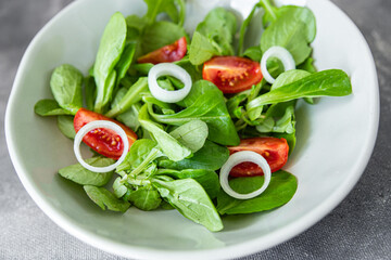 vegetable salad tomato, onion, lettuce mix, mache green fresh healthy meal food snack diet on the table copy space food background rustic top view keto or paleo diet veggie vegan or vegetarian food